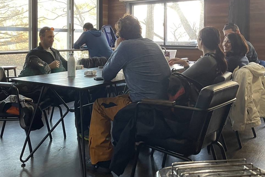 暖かい根子岳山荘で休憩しているスノーシューハイキングツアーの参加者